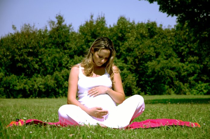 Беременная женщина отдыхает на природе
